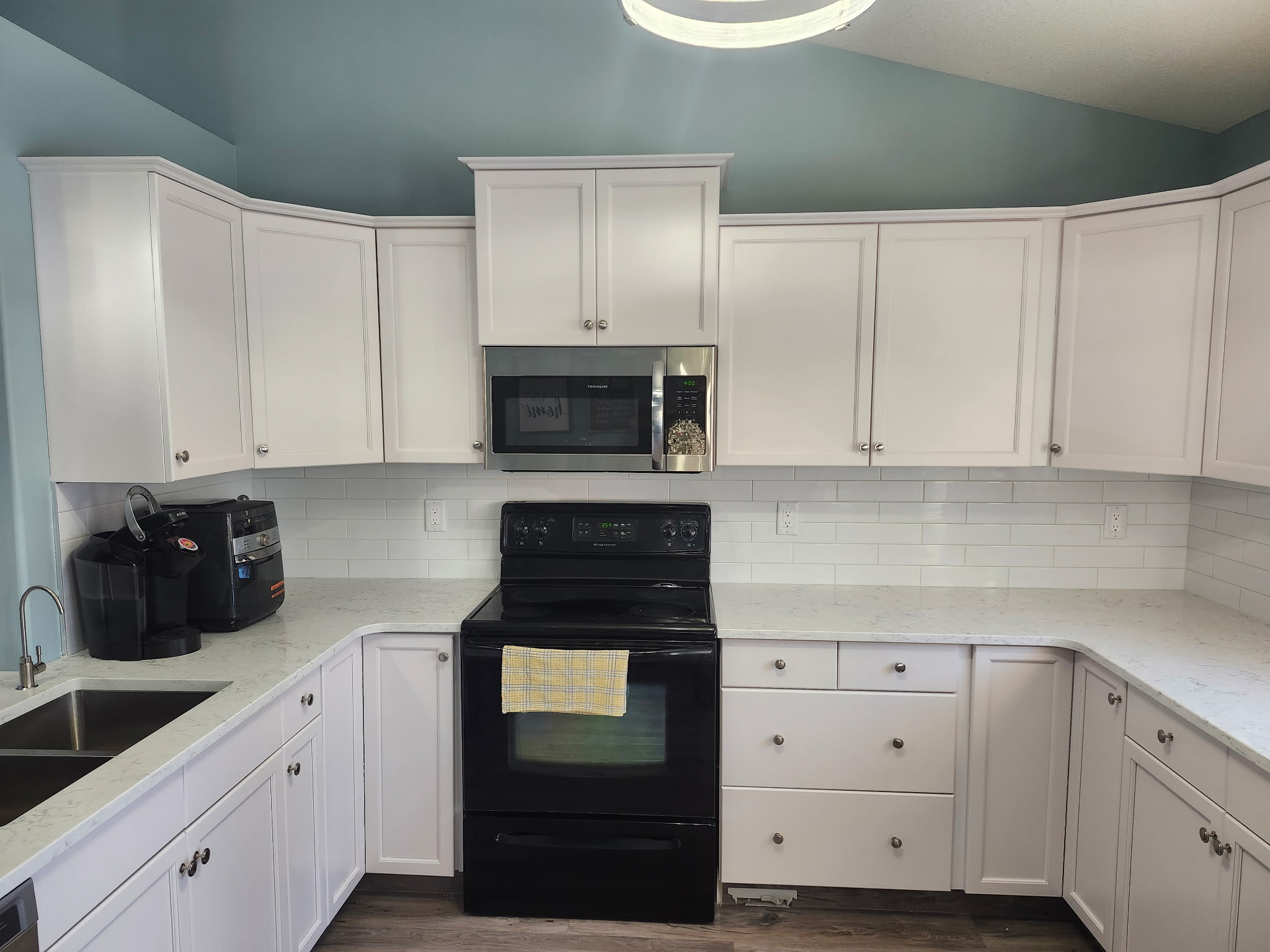 Finished kitchen with subway tile and white cabinets